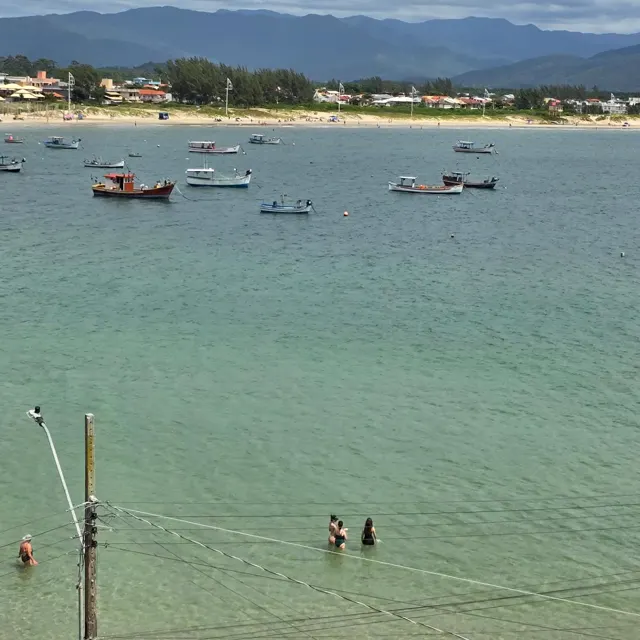 A baía de dia, mar verde e calmo com barcos